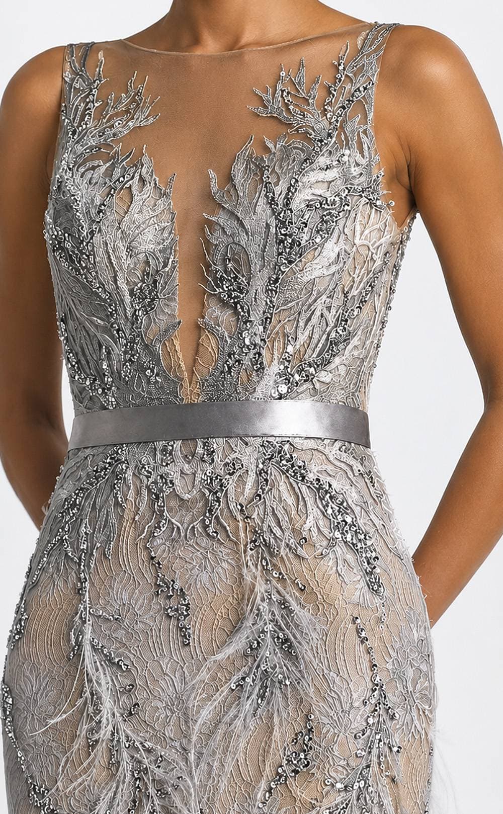 A close-up of an elegant dress featuring intricate silver embroidery and beadwork with a satin waistband.