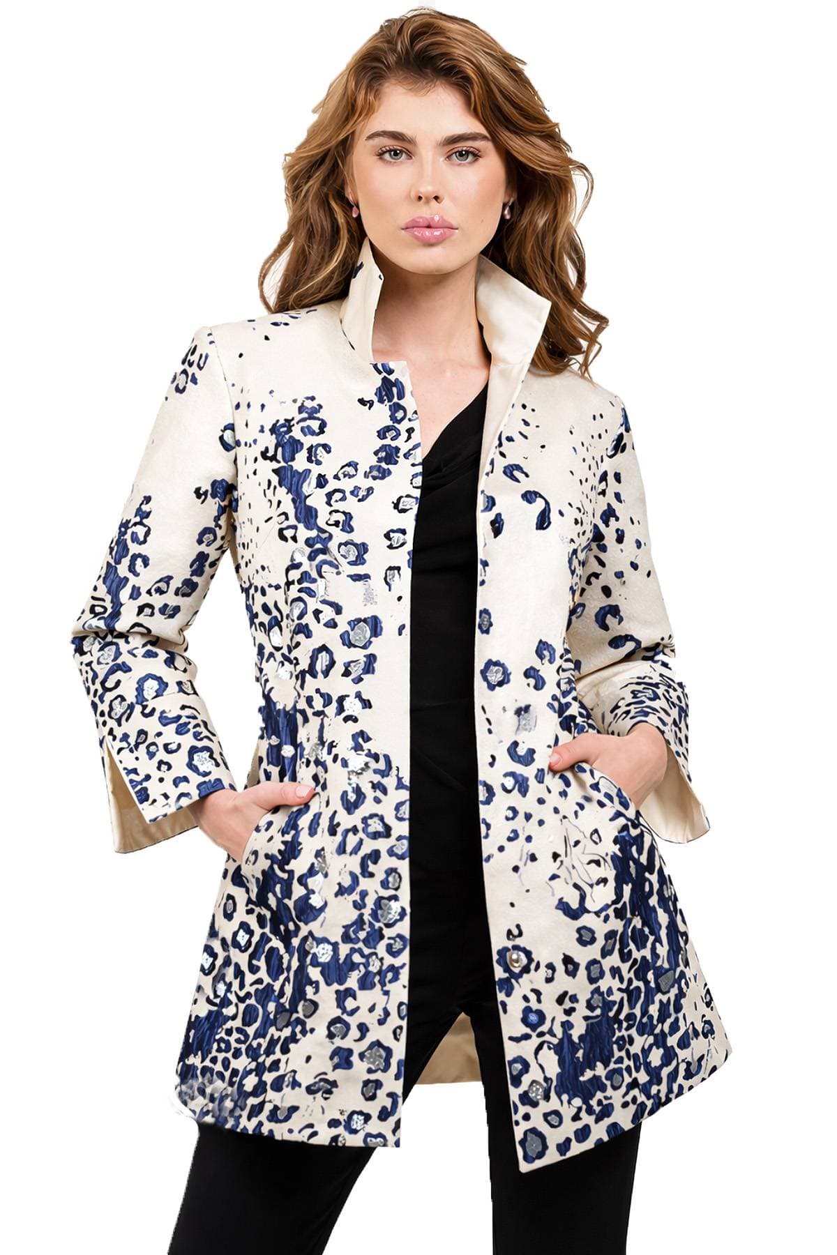 A person wearing a white coat with blue floral patterns and hands in pockets.