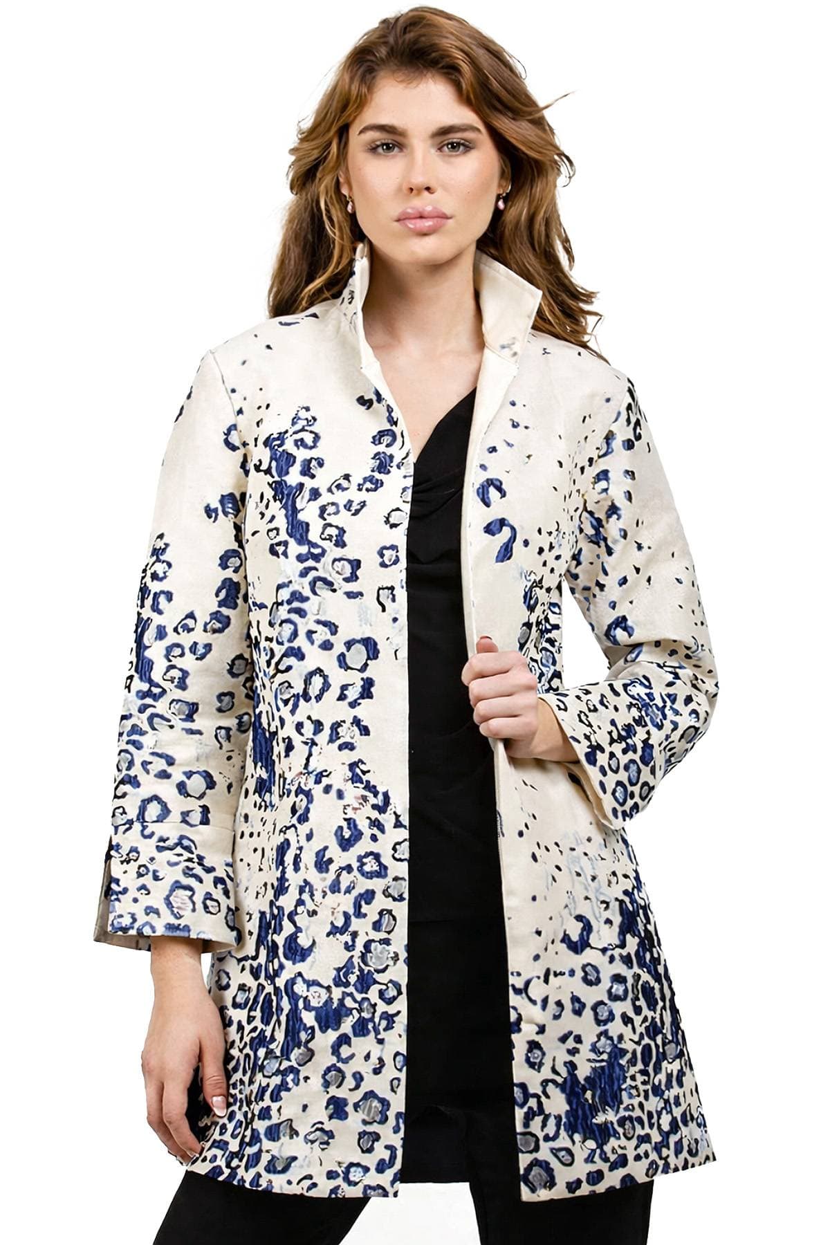 A woman wearing a white coat with blue abstract patterns.