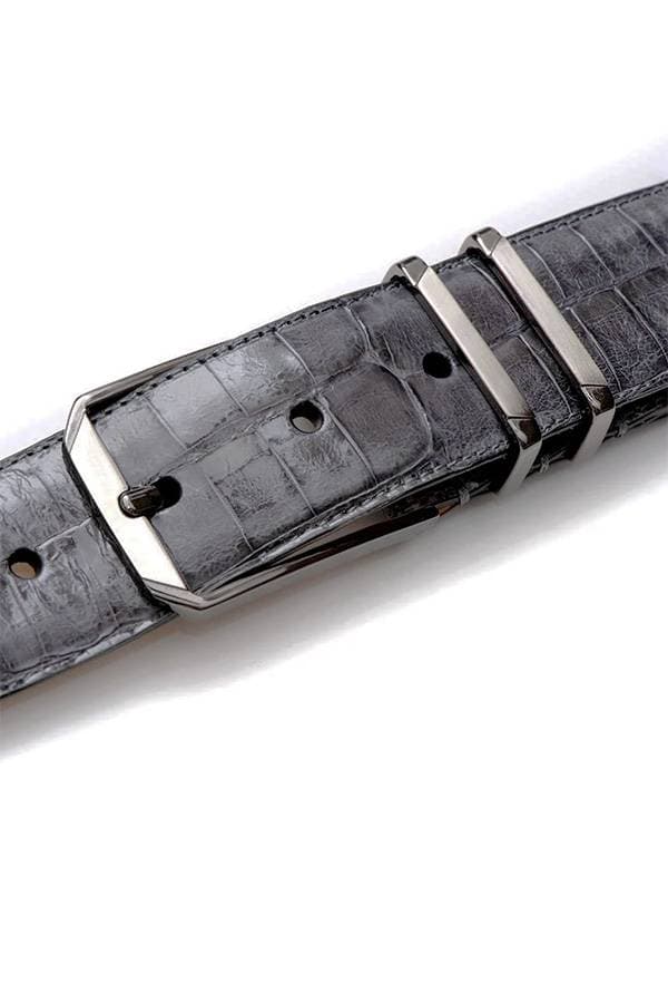 A Grey crocodile leather belt with a polished, textured finish, featuring a sleek silver buckle and double loops for added style and functionality. The rich grey color and exotic crocodile pattern add a luxurious touch to any outfit.