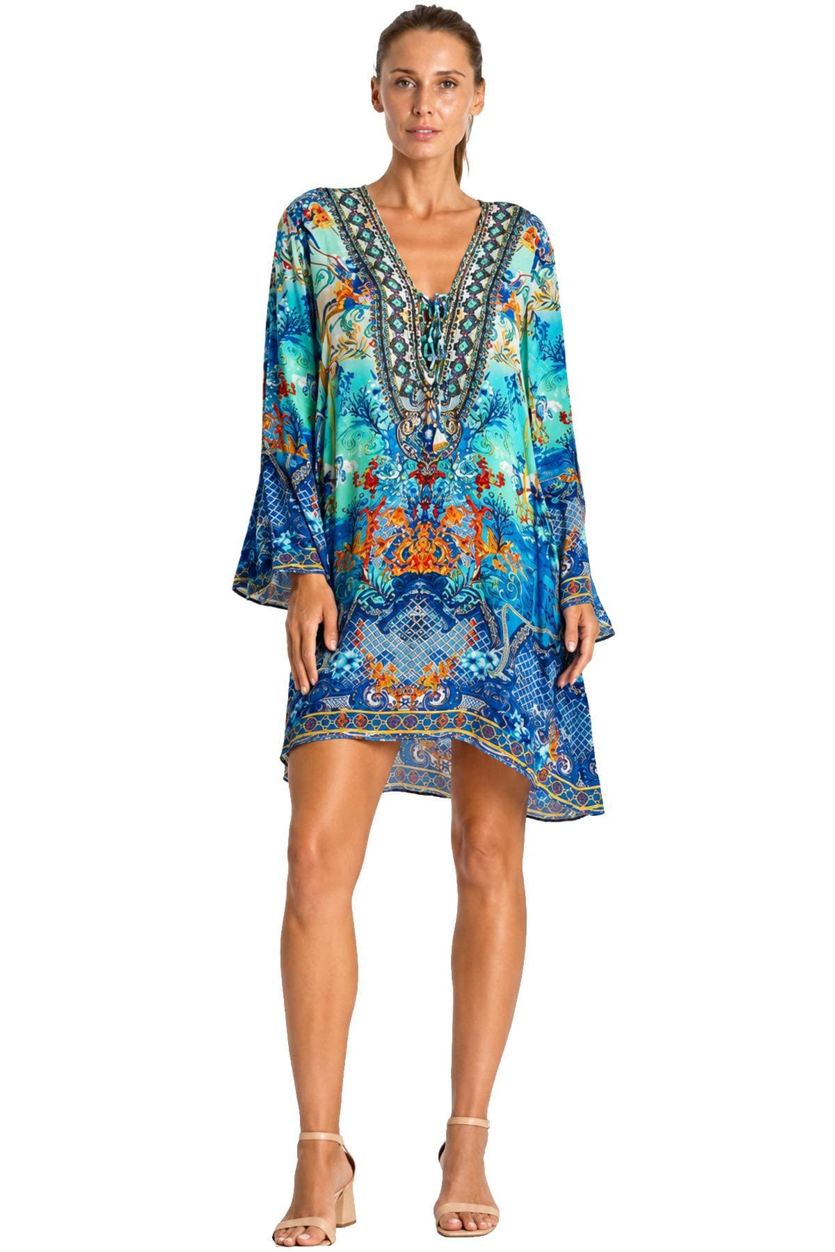 A person is wearing a colorful, patterned dress with long sleeves and a V-neck design.