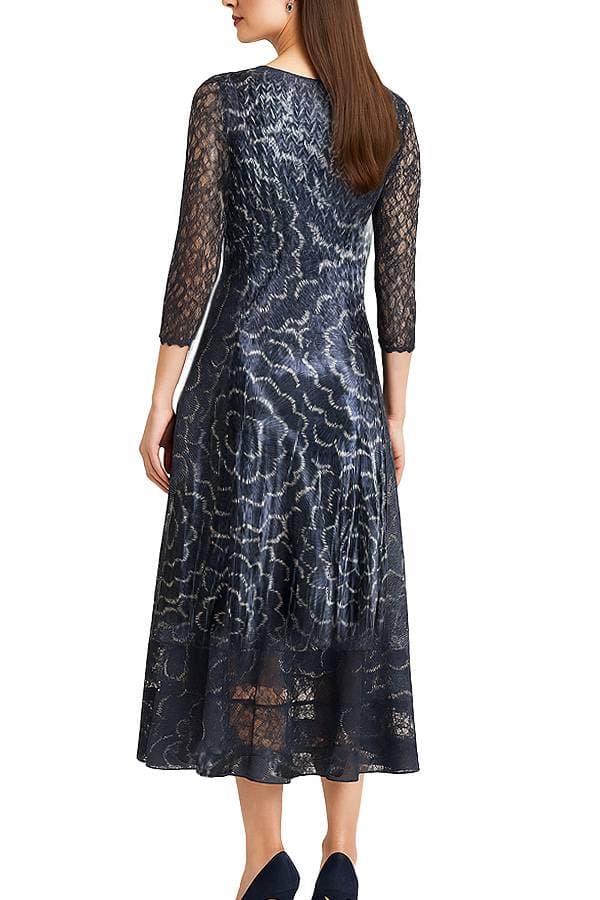Back view of a model wearing a navy and black lace midi dress displayed against a white background, floating as if on an invisible mannequin. The dress has a V-neckline, three-quarter lace sleeves, and a flared A-line skirt with a large floral pattern