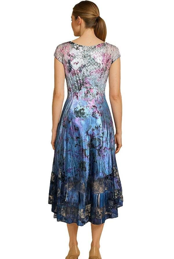 Back view Front view of a model wearing a blue and purple floral satin midi dress with cap sleeves and a V-neckline. The dress has a fitted waist, flared skirt, and dark lace trim at the hem, paired with nude heels.