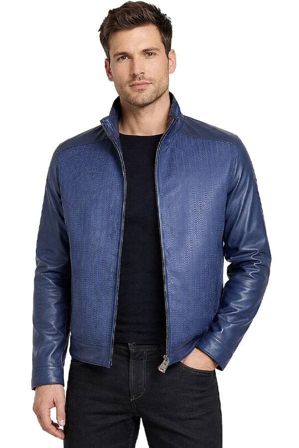 A man wearing a blue leather jacket over a black shirt with his hands in his pockets.