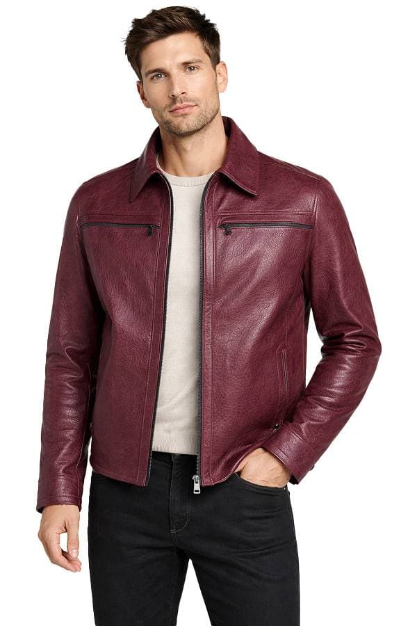 A man wearing a burgundy leather jacket over a light shirt and black pants.