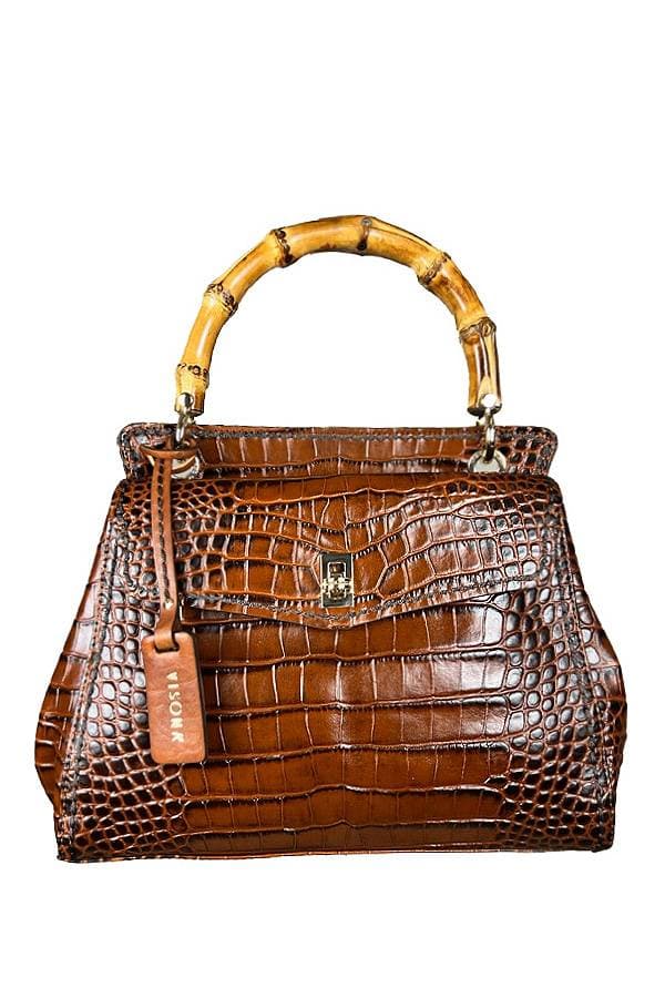 A brown crocodile-pattern handbag with a bamboo handle and a small leather tag.
