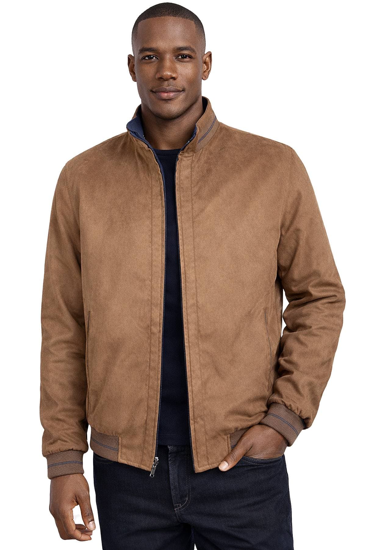 A person wearing a brown zip-up jacket with a hand in one pocket.