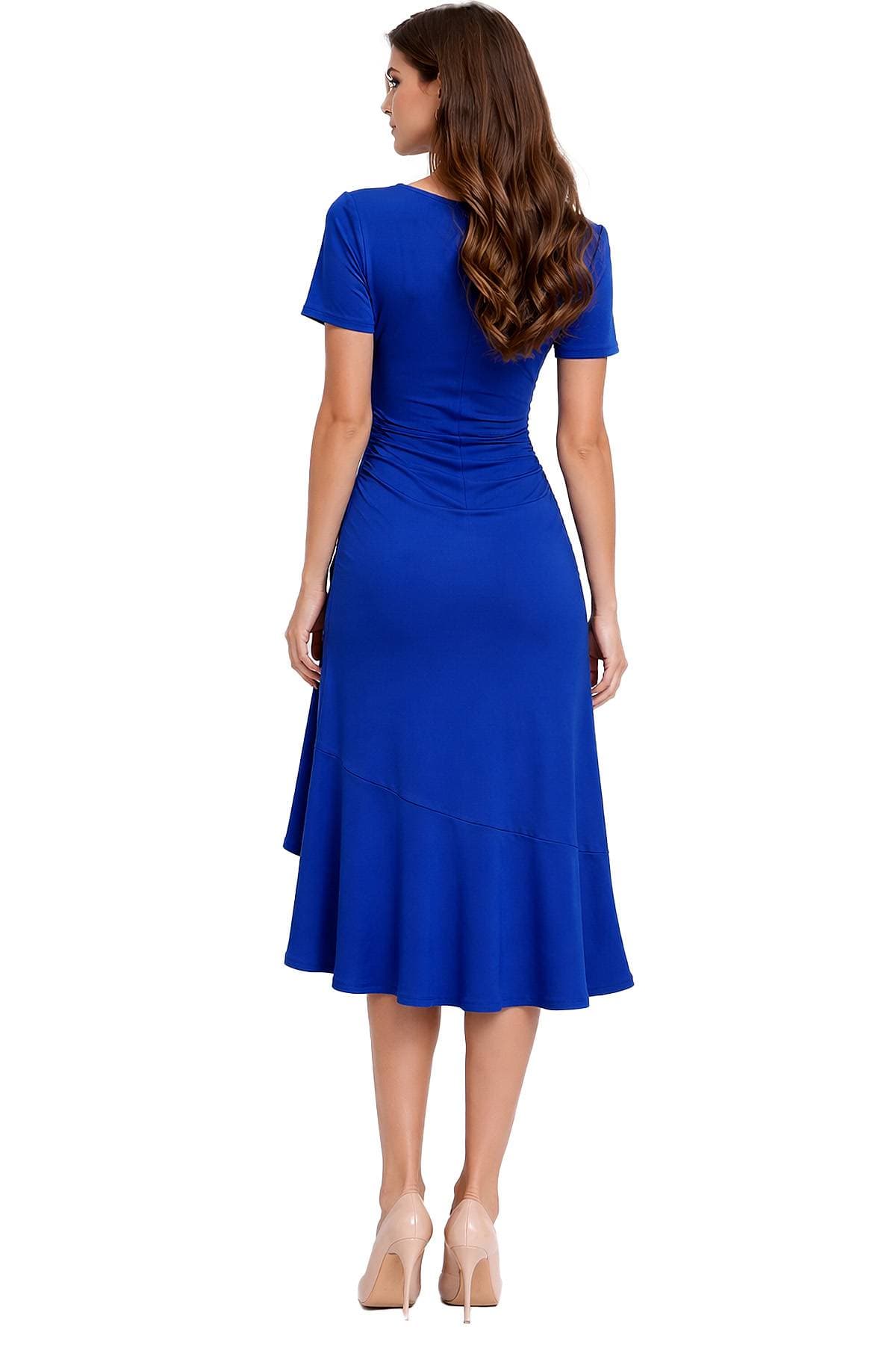 A woman in a vibrant blue dress and beige heels is standing with her back to the camera.