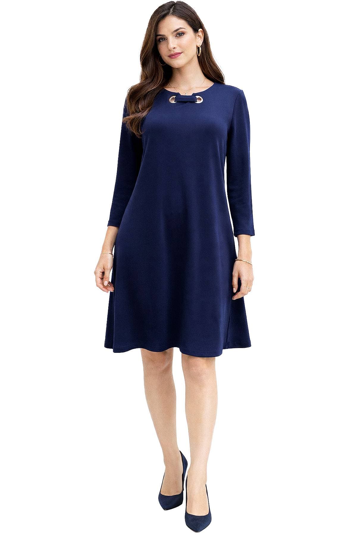 A woman wearing a knee-length, long-sleeved navy blue dress and matching heels.