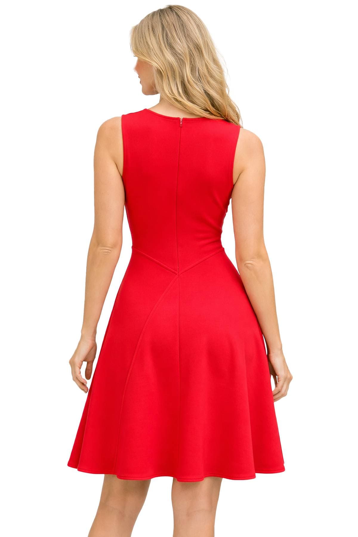 A person with long blonde hair is wearing a sleeveless red dress, photographed from behind.