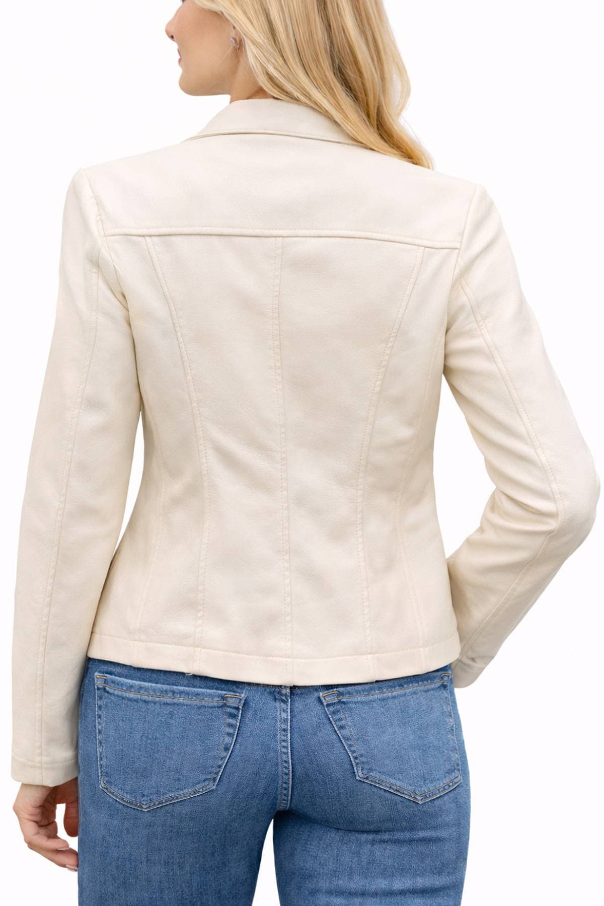 A woman wearing a cream-colored jacket and blue jeans is seen from the back.