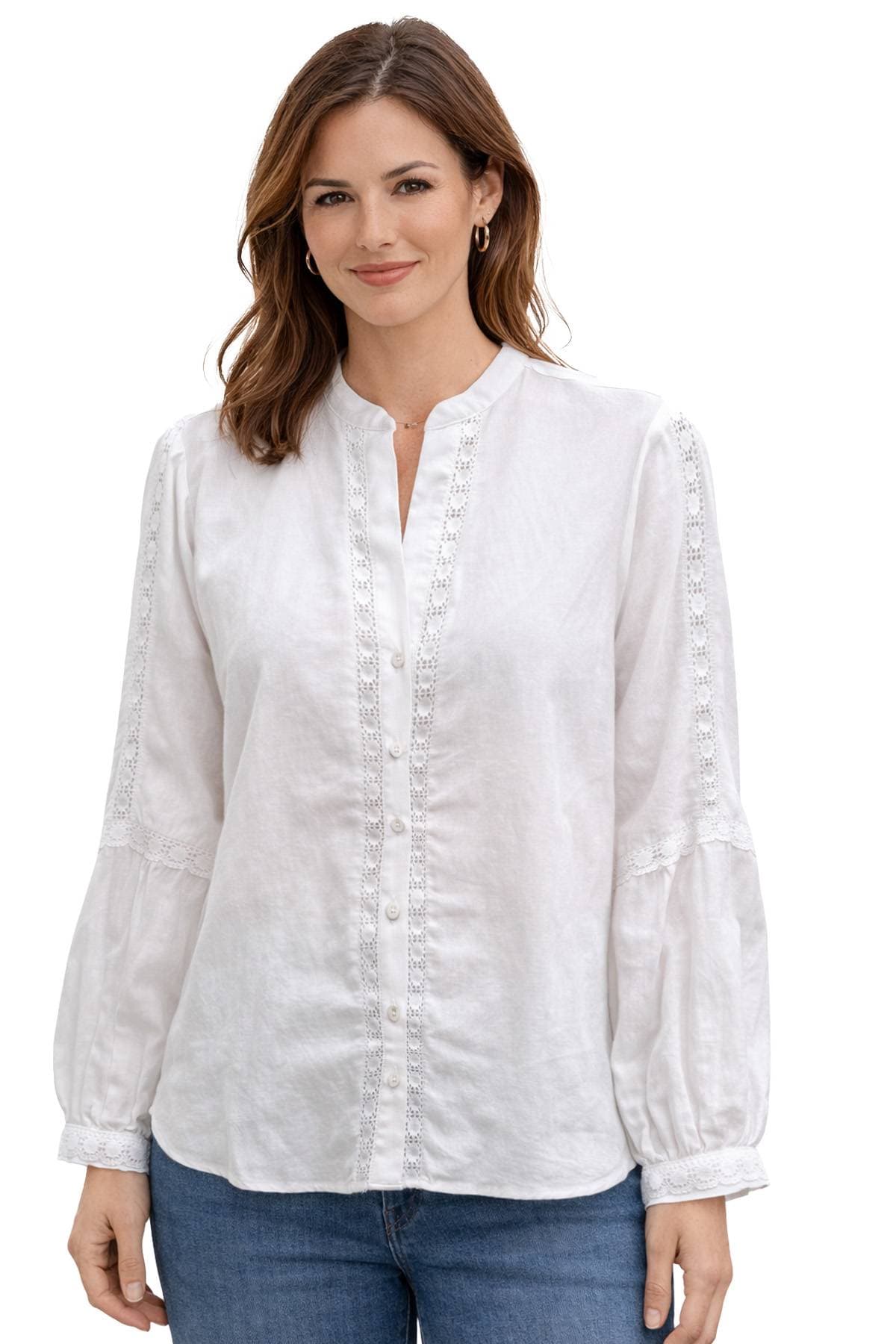 A woman wearing a white blouse with lace details and blue jeans.
