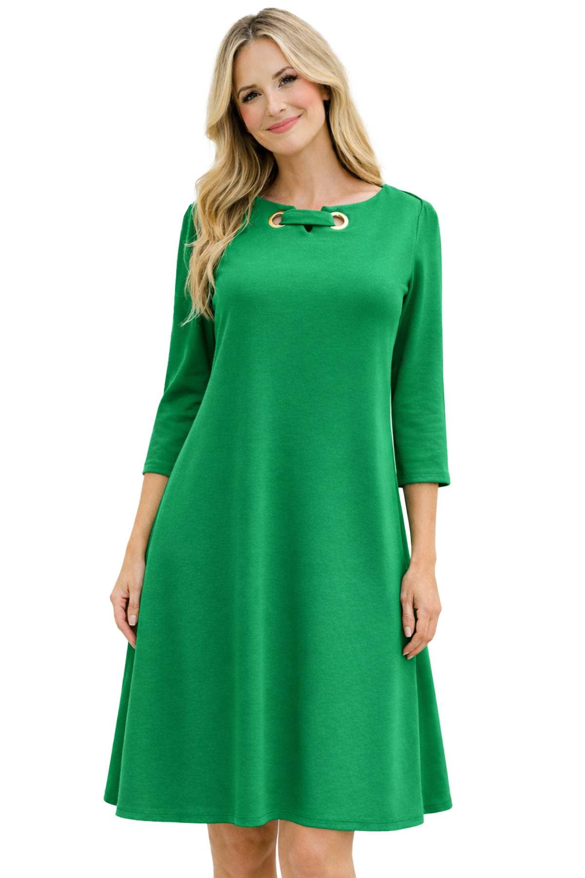 A person wearing a green, knee-length dress with three-quarter sleeves and a decorative neckline.