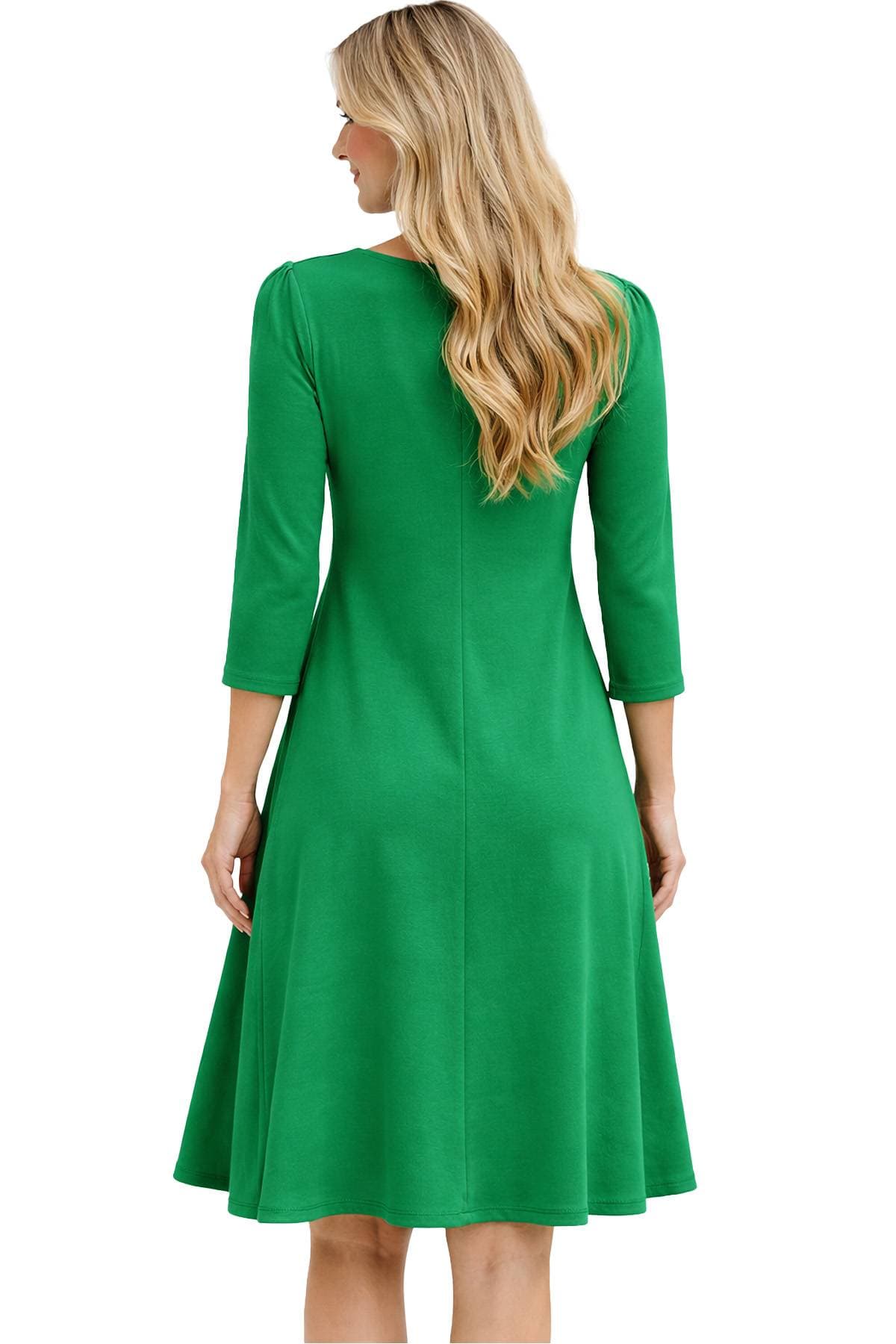 A person in a green dress with long sleeves is facing away.
