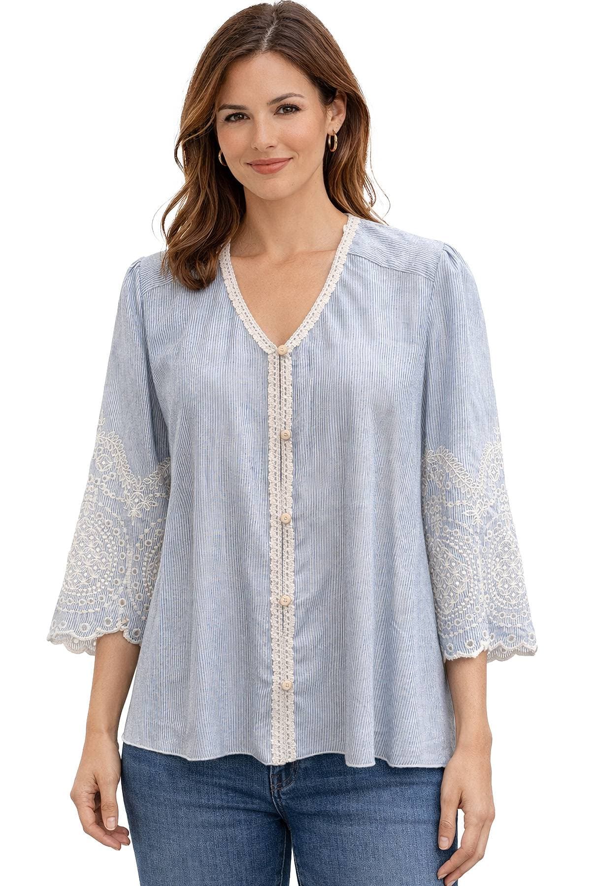 A woman is wearing a light blue blouse with intricate lace detailing on the sleeves and a row of buttons down the front.
