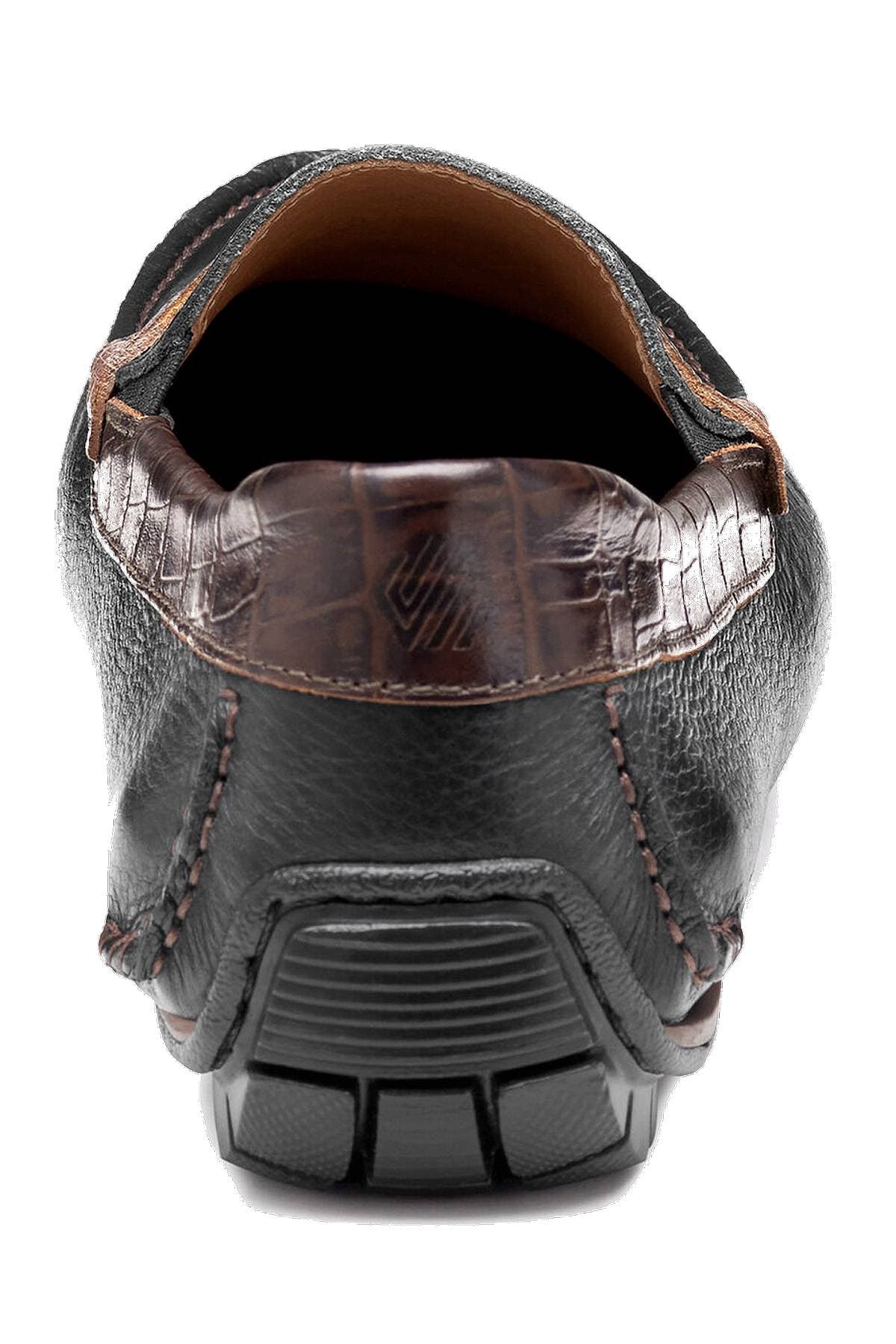 Close-up of the back of a black leather shoe with a brown crocodile-textured trim and a sturdy sole.