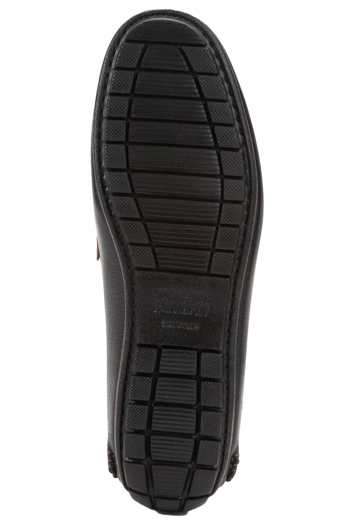 The image shows the sole of a black shoe with a textured, grid-like pattern.