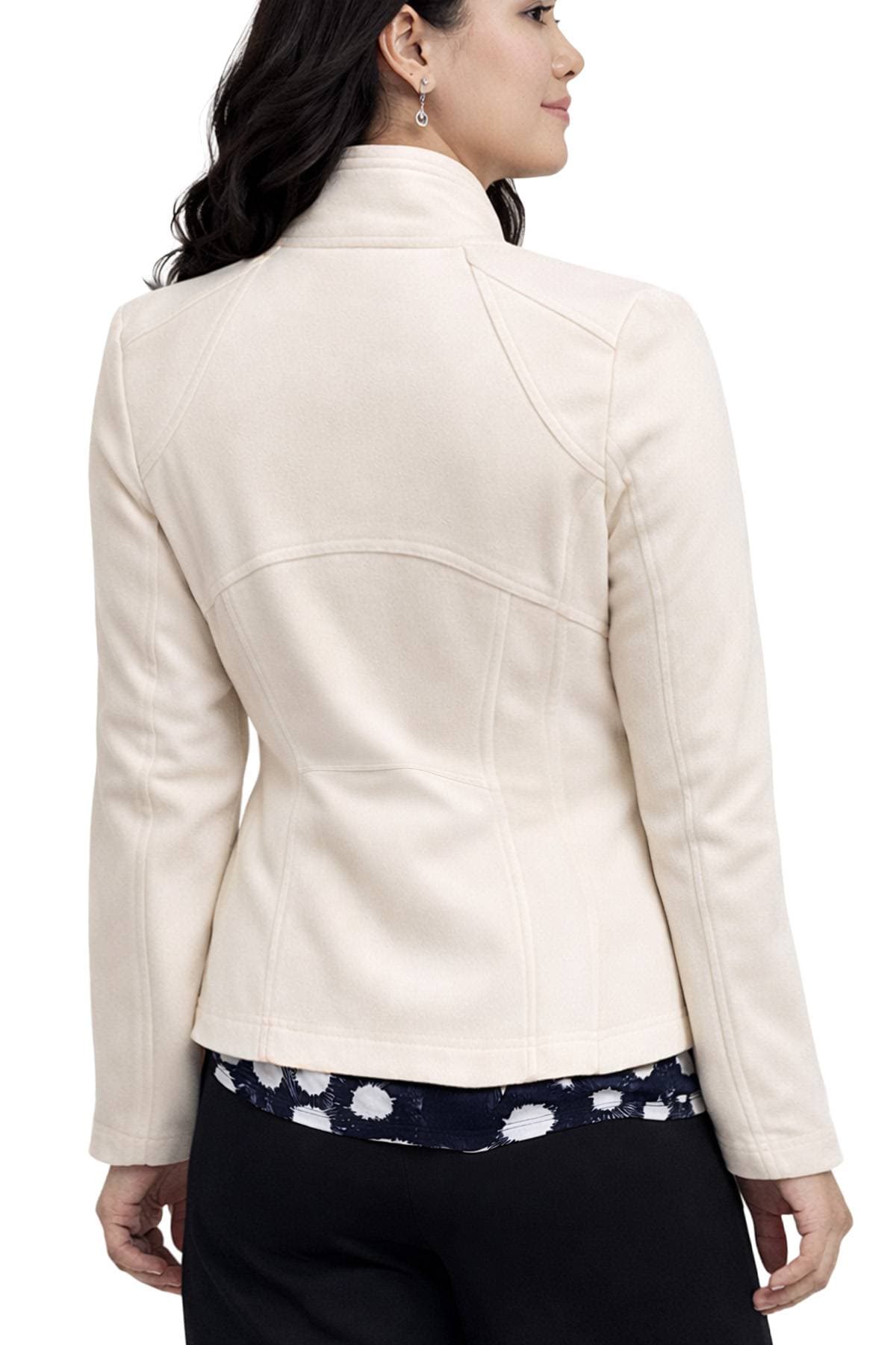 A woman wearing a light beige jacket with a patterned shirt underneath, viewed from the back.