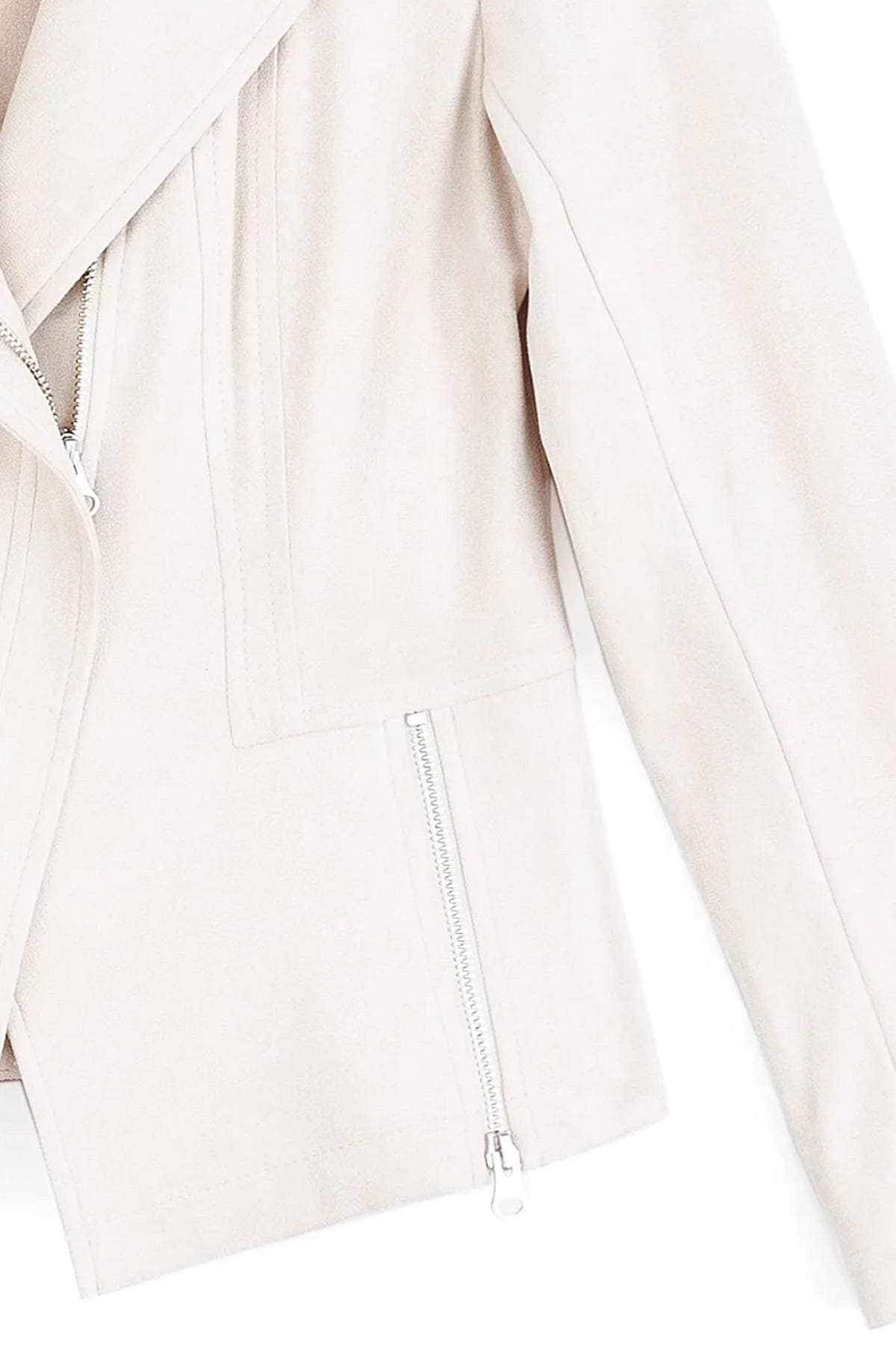 Close-up of a light-colored jacket with visible zippers.