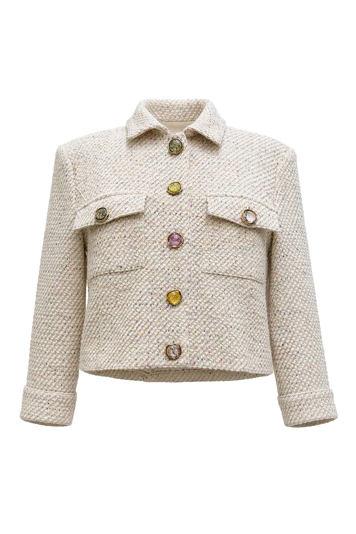 A cream-colored tweed jacket with multiple colored buttons and flap pockets.