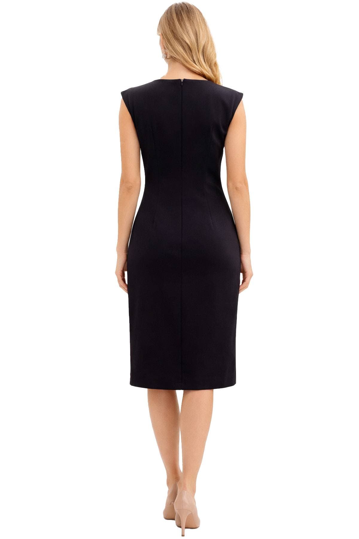 A woman is wearing a sleeveless black dress and beige heels, viewed from the back.