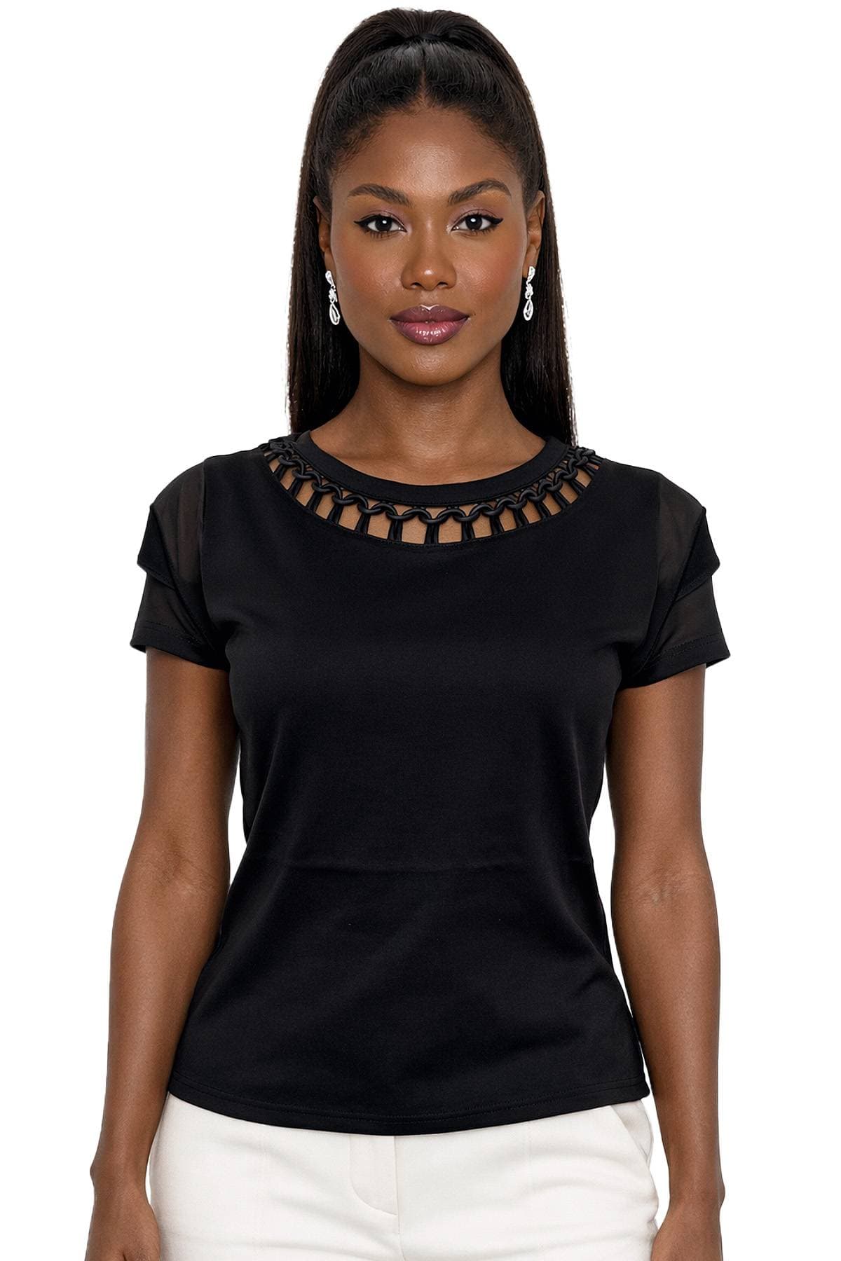 A woman is wearing a black top with intricate neckline detail and earrings.
