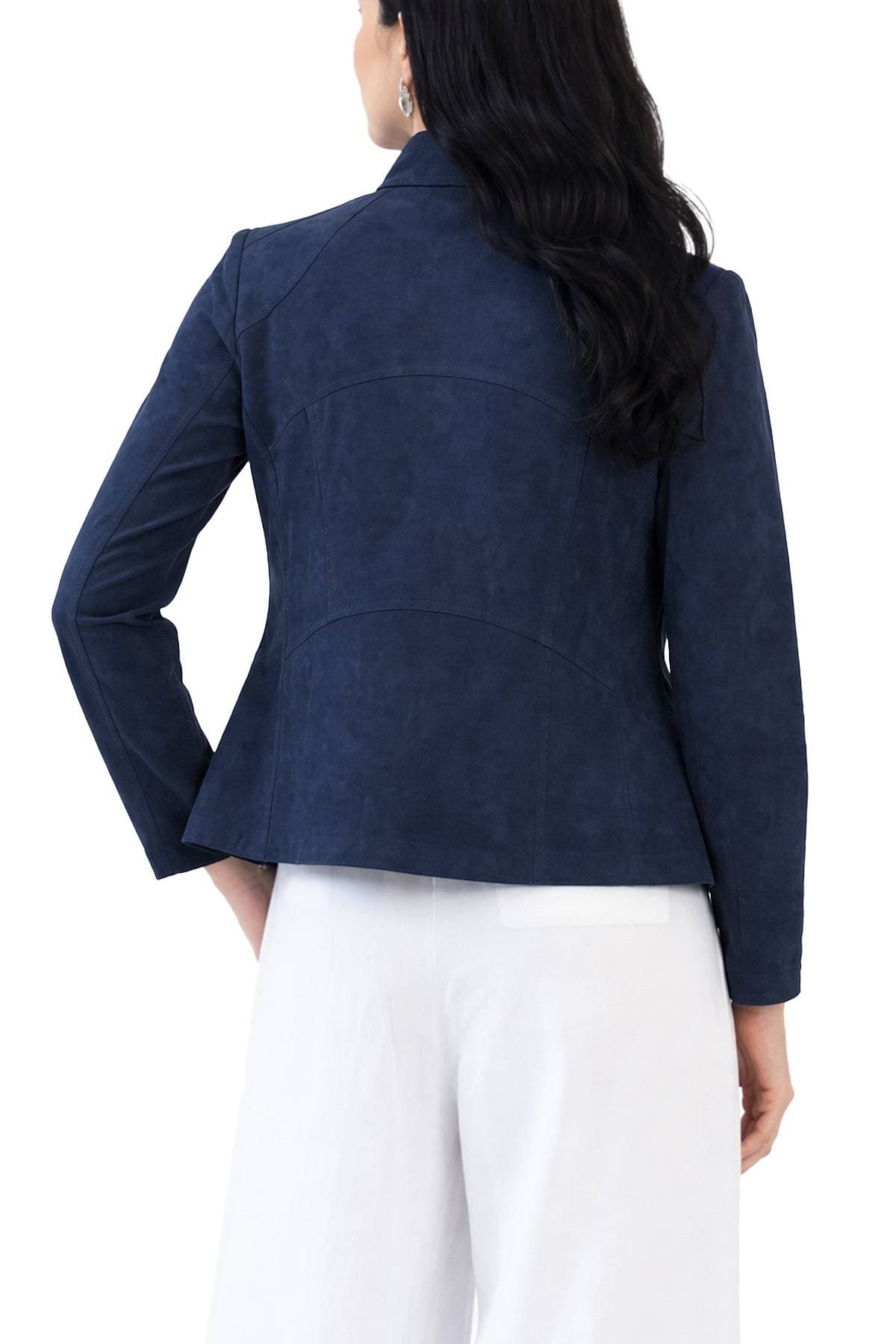 A woman with long dark hair is wearing a navy blue blazer and white pants, viewed from behind.
