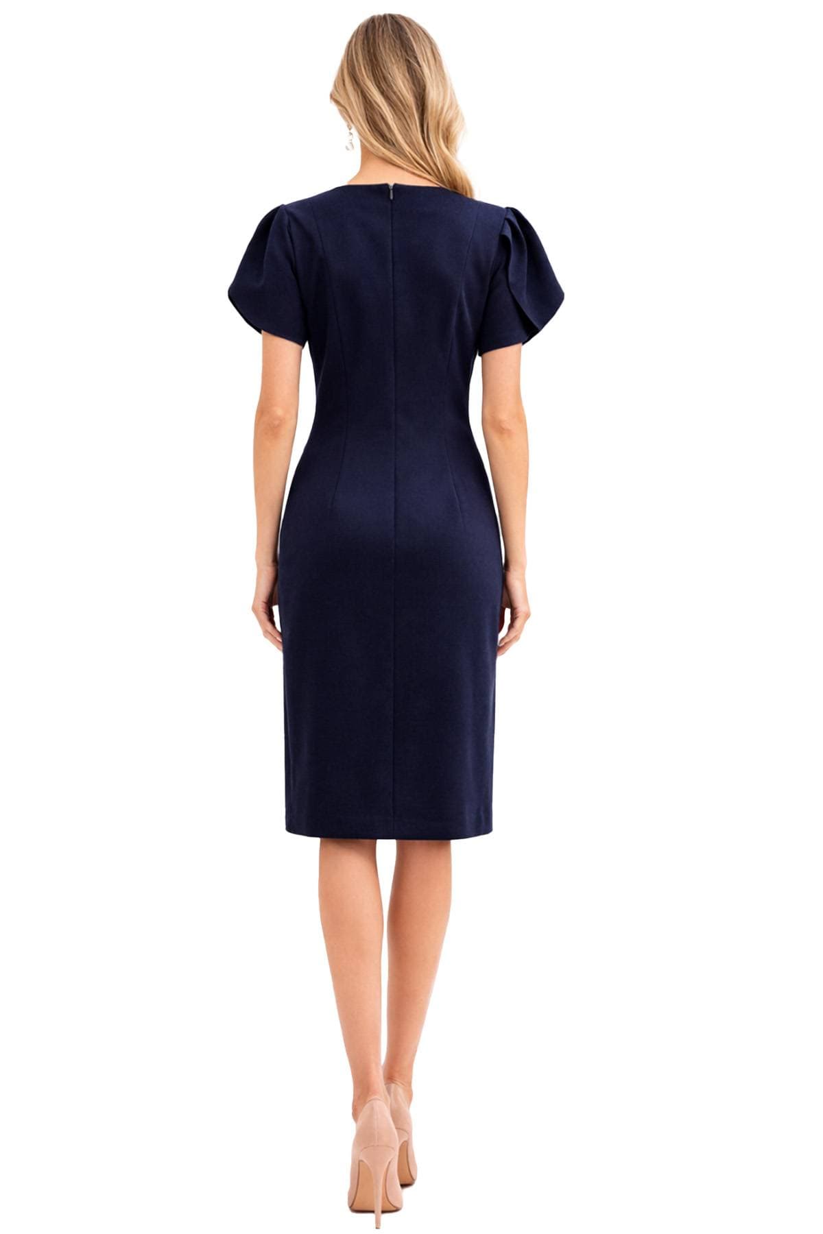 A woman is wearing a navy blue dress with short puff sleeves, viewed from the back.