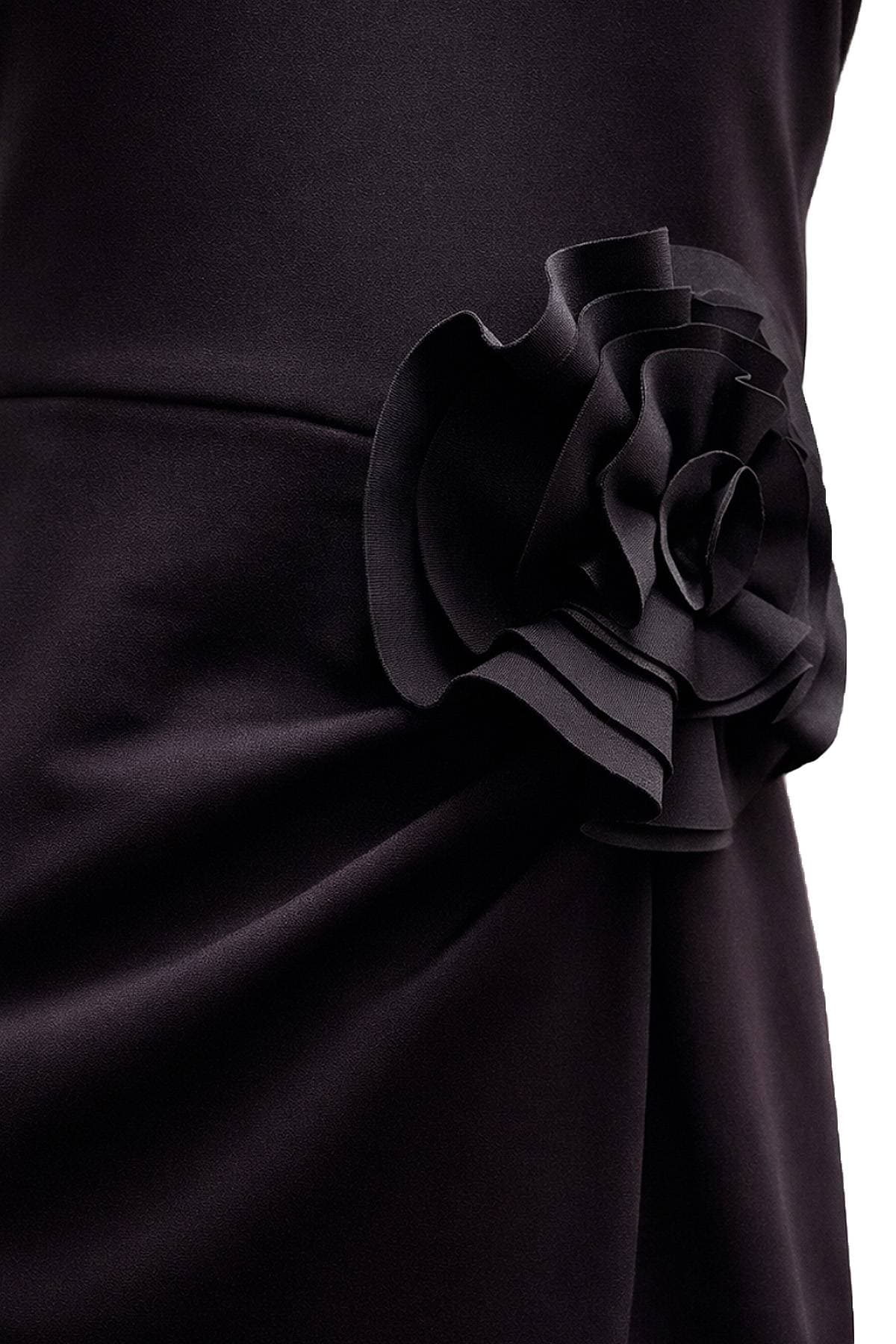 Close-up of a black fabric flower embellishment on a garment.