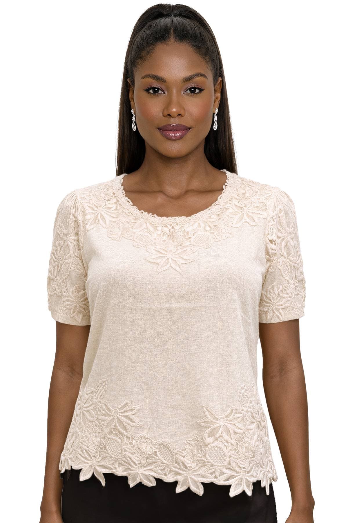 A woman with long hair wearing a cream lace top and drop earrings.