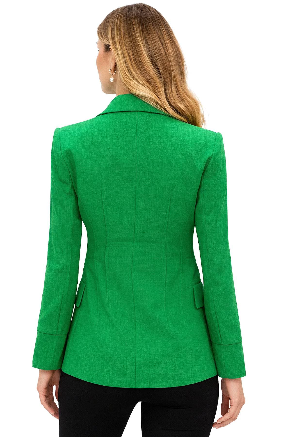 A woman with long blonde hair is wearing a bright green blazer viewed from the back.