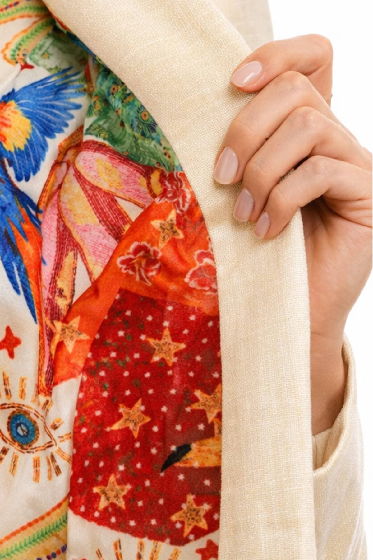 A hand holding open a beige jacket reveals a vibrant, multi-colored patterned lining.