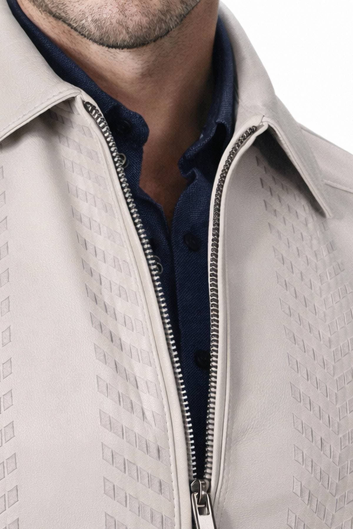 Close-up of a person wearing a patterned light-colored leather jacket over a dark button-up shirt.