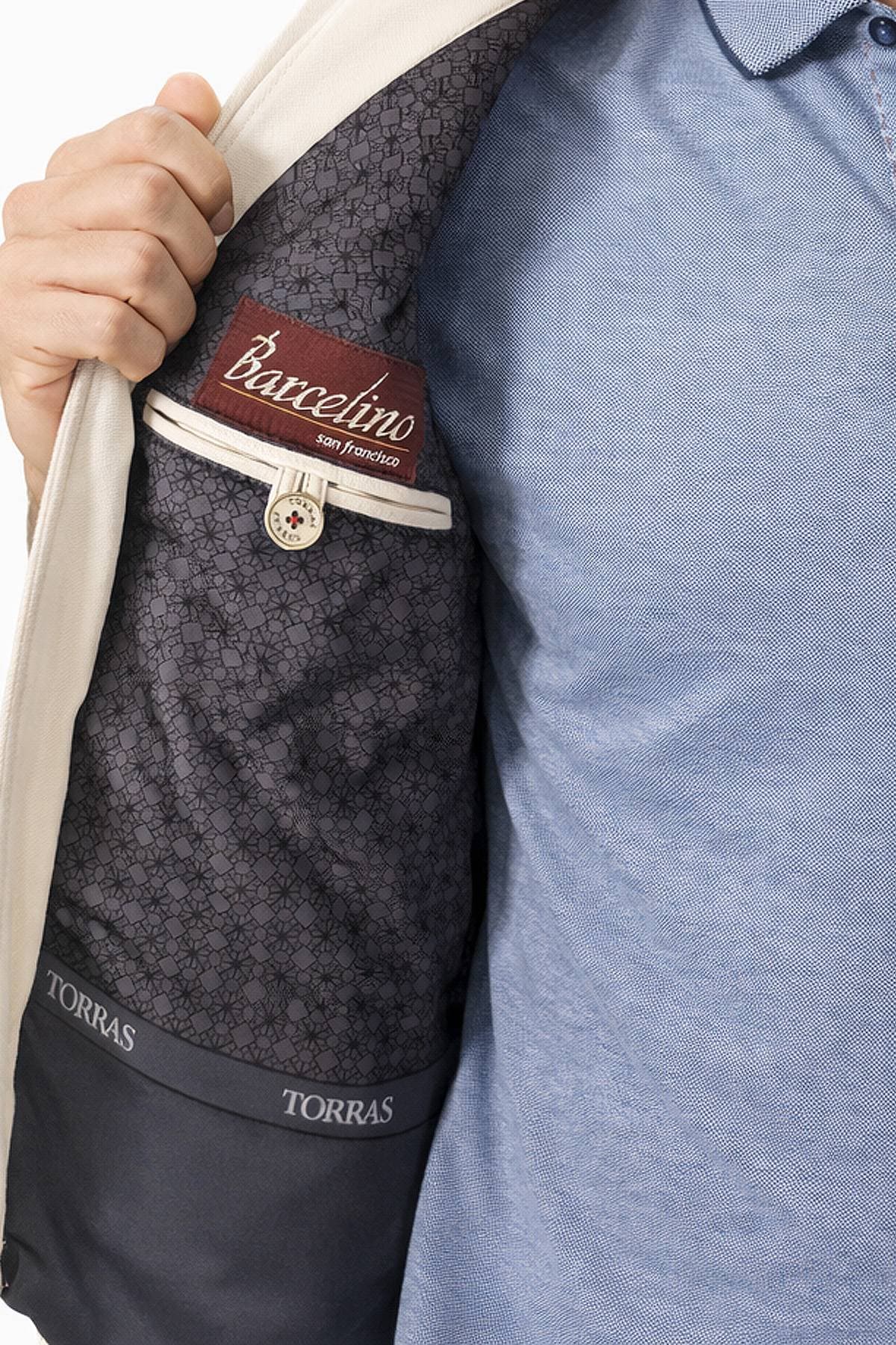 A person is opening the inner lining of a jacket to reveal clothing labels.