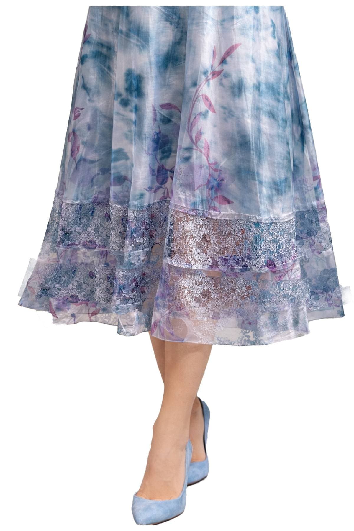 A woman is wearing a blue and purple floral lace skirt with matching blue shoes.