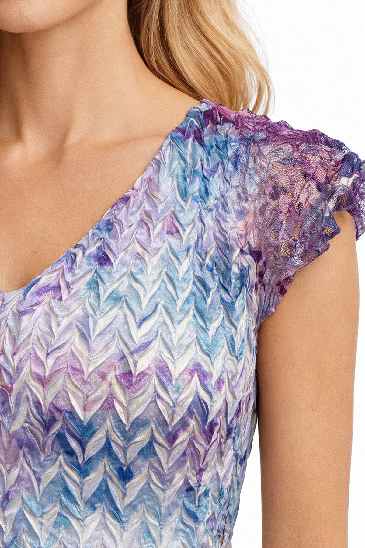 A close-up of a woman's shoulder and upper torso wearing a colorful textured dress with lace detailing on the sleeve.