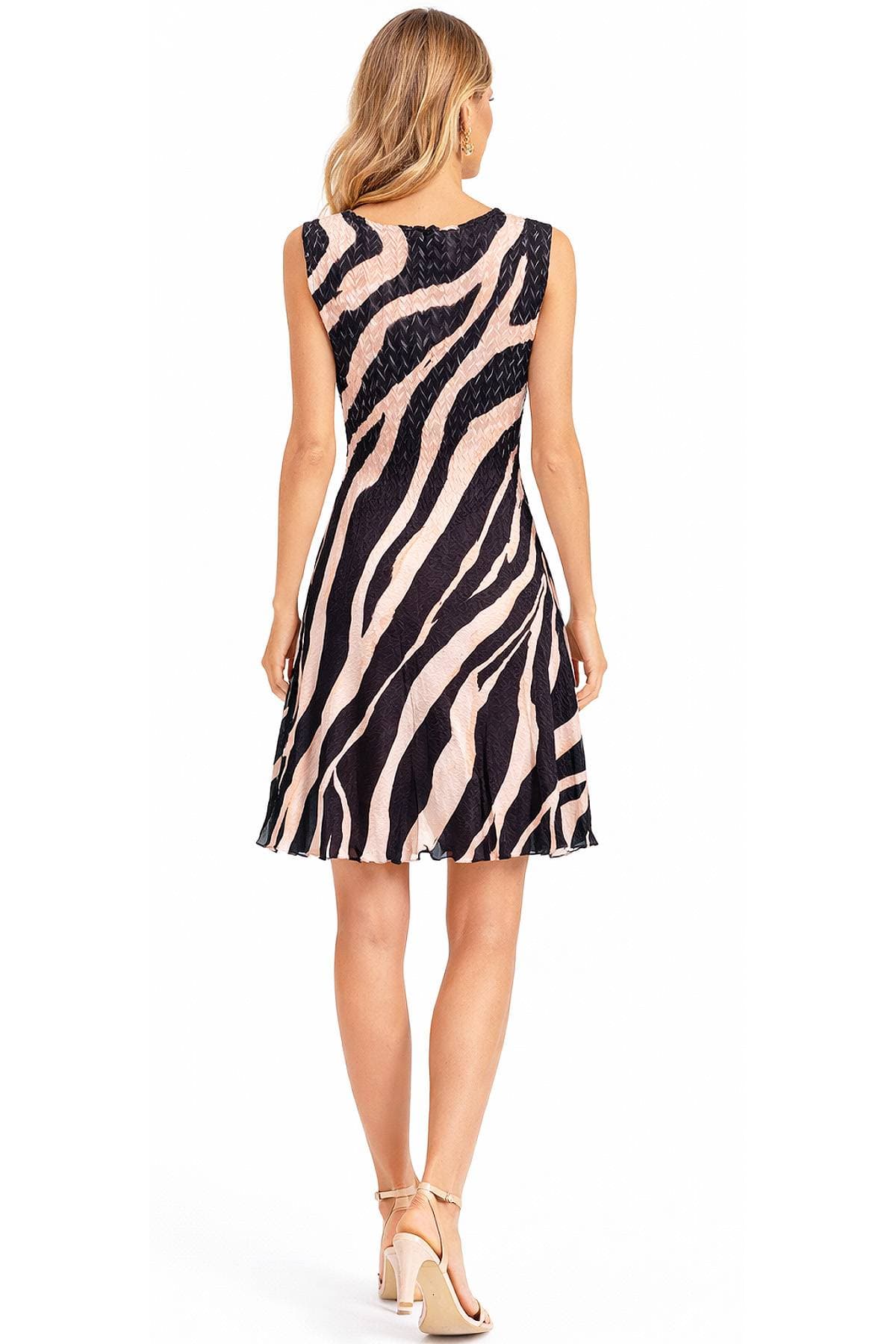 A woman wearing a zebra-striped dress and high heels stands with her back to the camera.