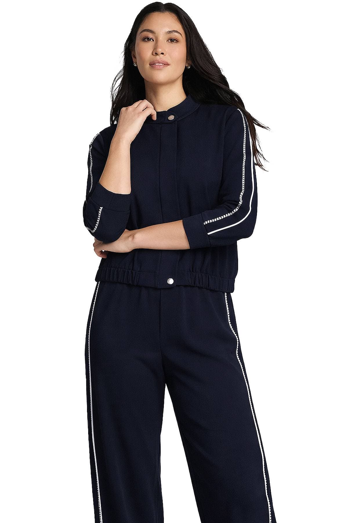 A woman wearing a navy blue tracksuit with white piping details.