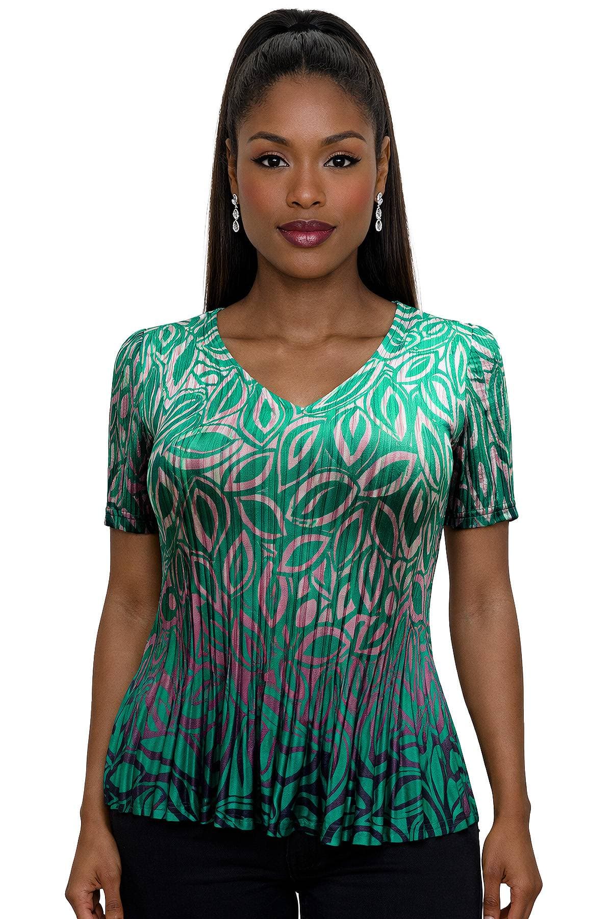 A woman wearing a green and pink patterned top with drop earrings.