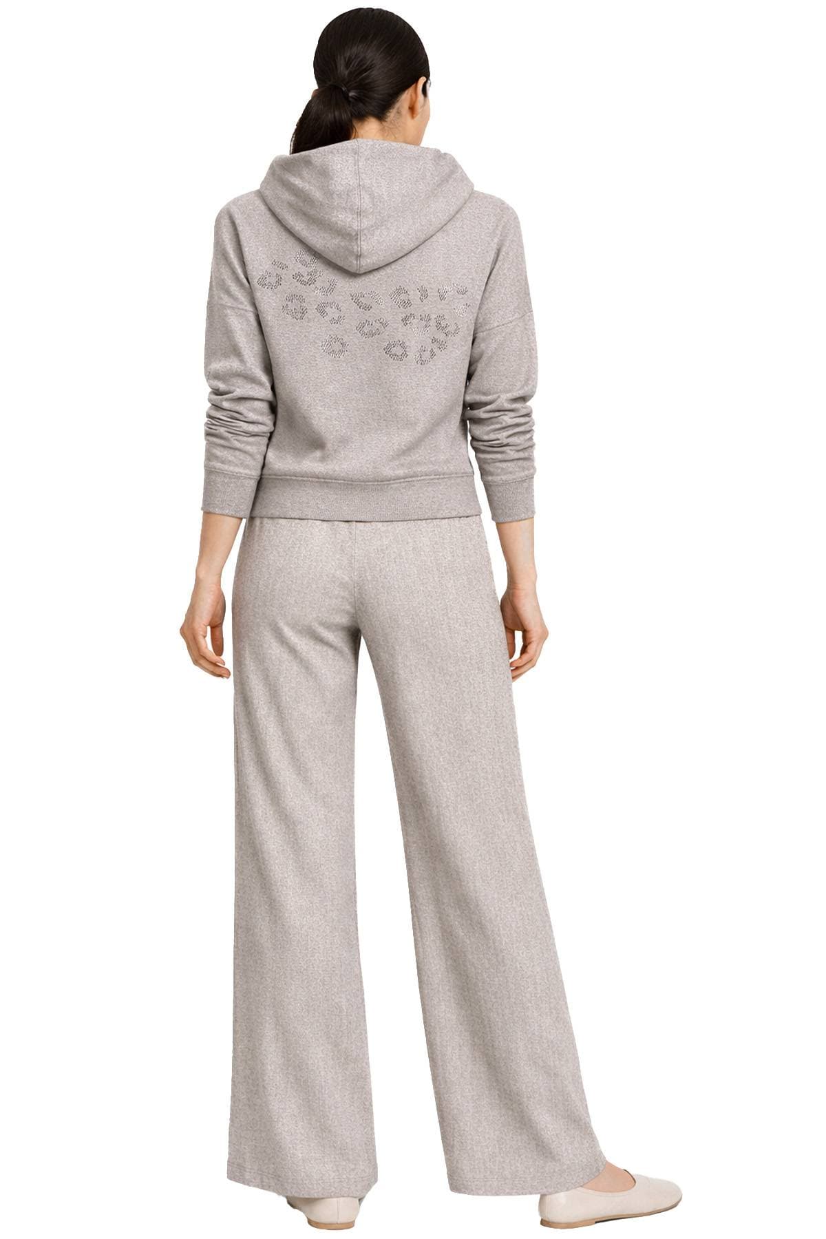 A person is wearing a gray sweatshirt with a hood and matching wide-leg pants, viewed from behind.
