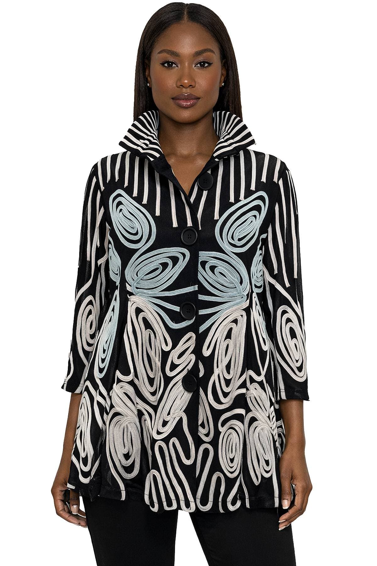A person wearing a long-sleeved black and white patterned coat with large buttons and a striped collar.