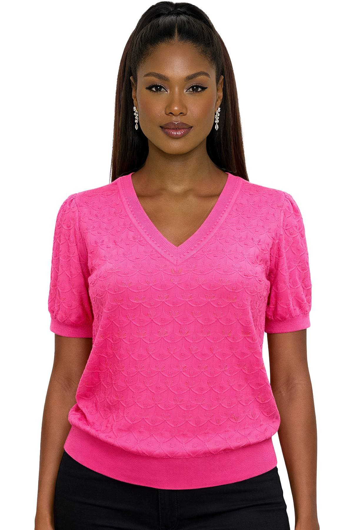 A woman with long hair is wearing a bright pink textured V-neck blouse and earrings.