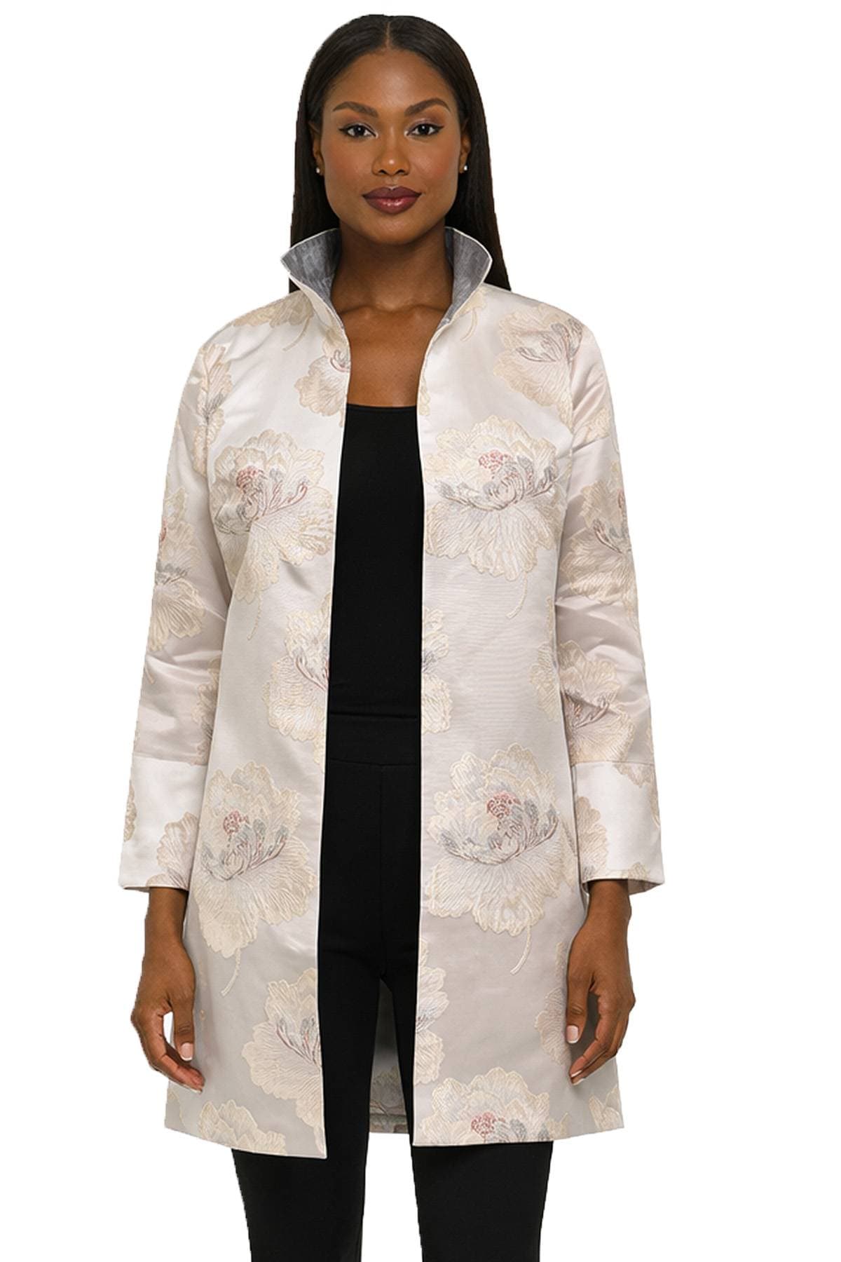 A person wearing a floral patterned, open-front jacket with a high collar.