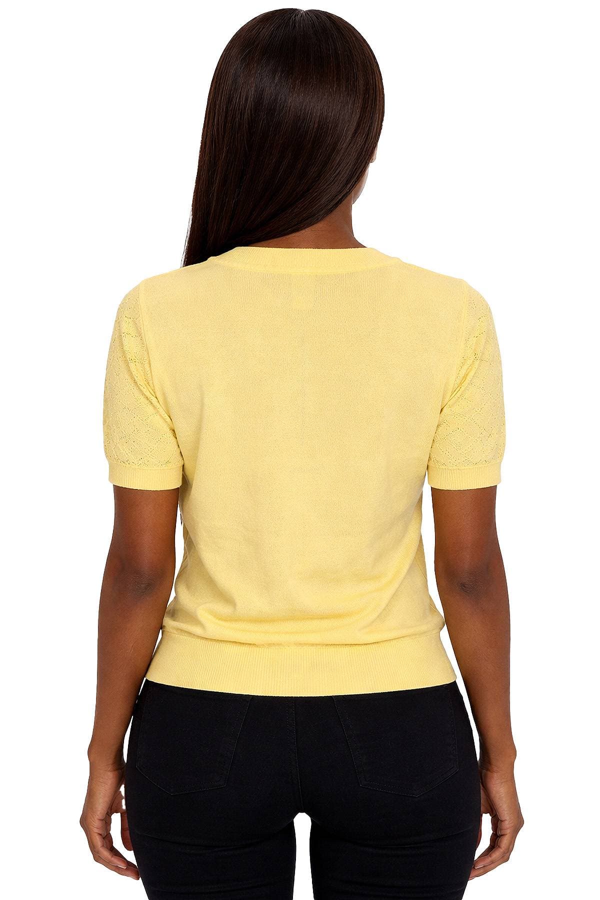 A person with long hair is wearing a yellow short-sleeved top and dark pants, viewed from the back.