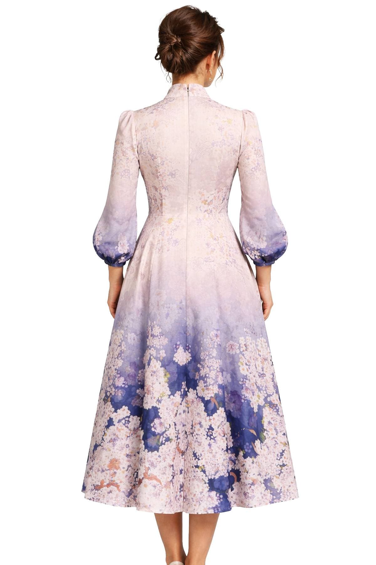 A woman is wearing a long-sleeved, floral-patterned dress with a gradient design that fades from light to dark purple.