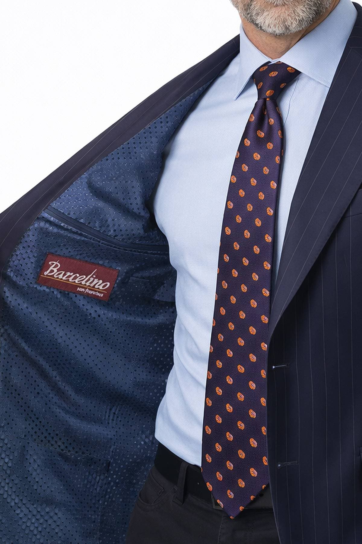 A man wearing a pinstriped suit reveals the patterned inner lining of his jacket.