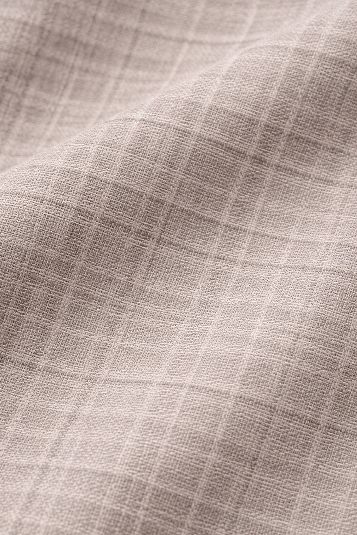 Close-up of a beige fabric with a subtle checkered pattern.
