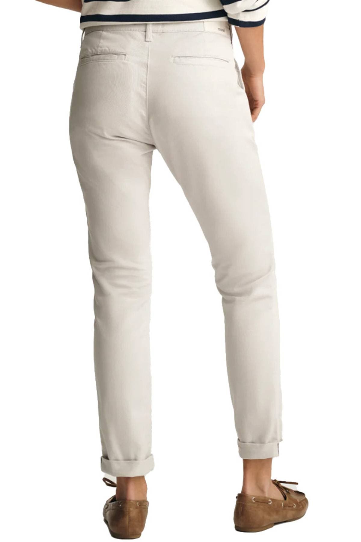 A person is wearing light-colored pants and brown loafers, viewed from the back.