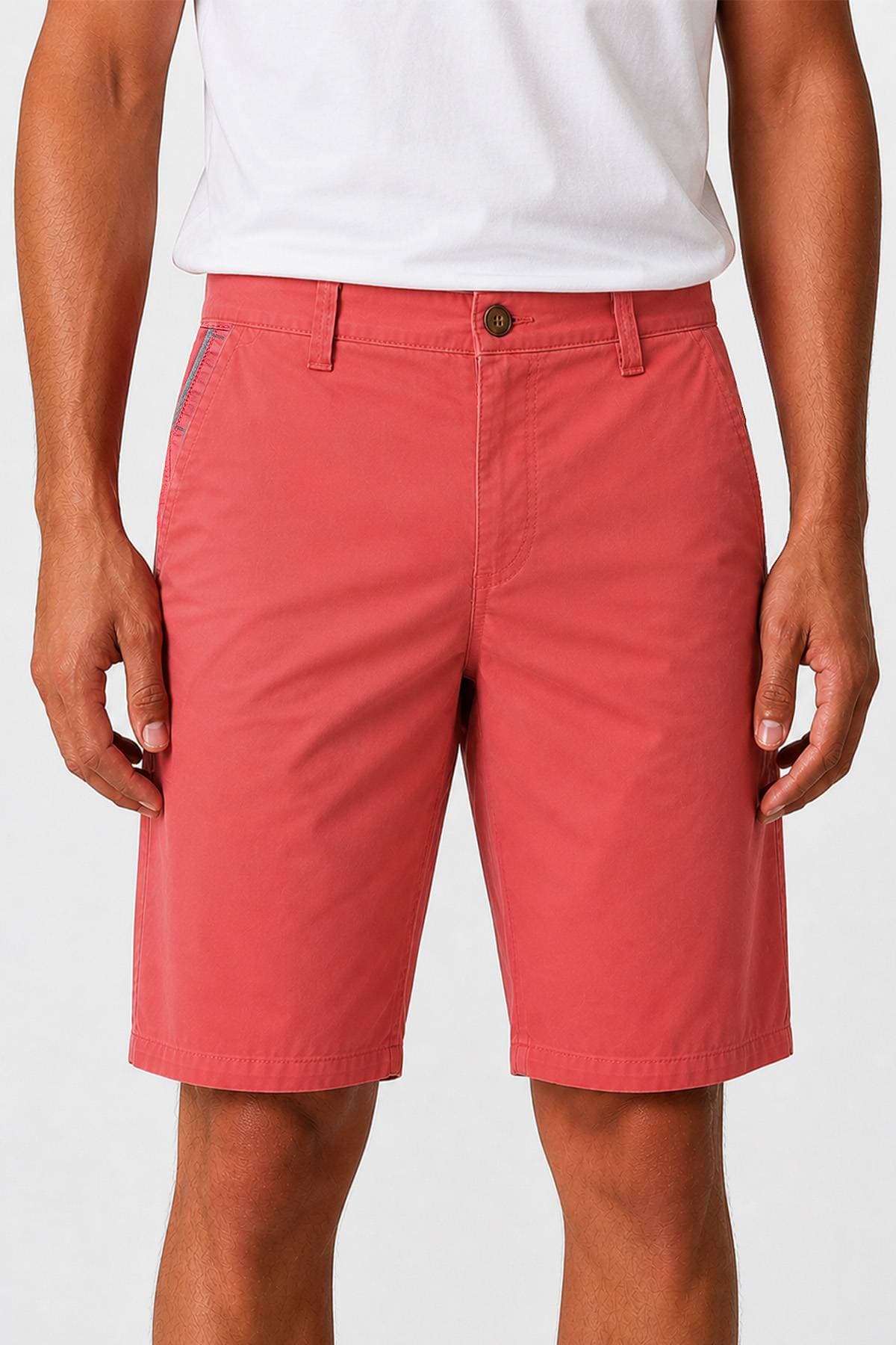 A person wearing coral-colored shorts and a white t-shirt.