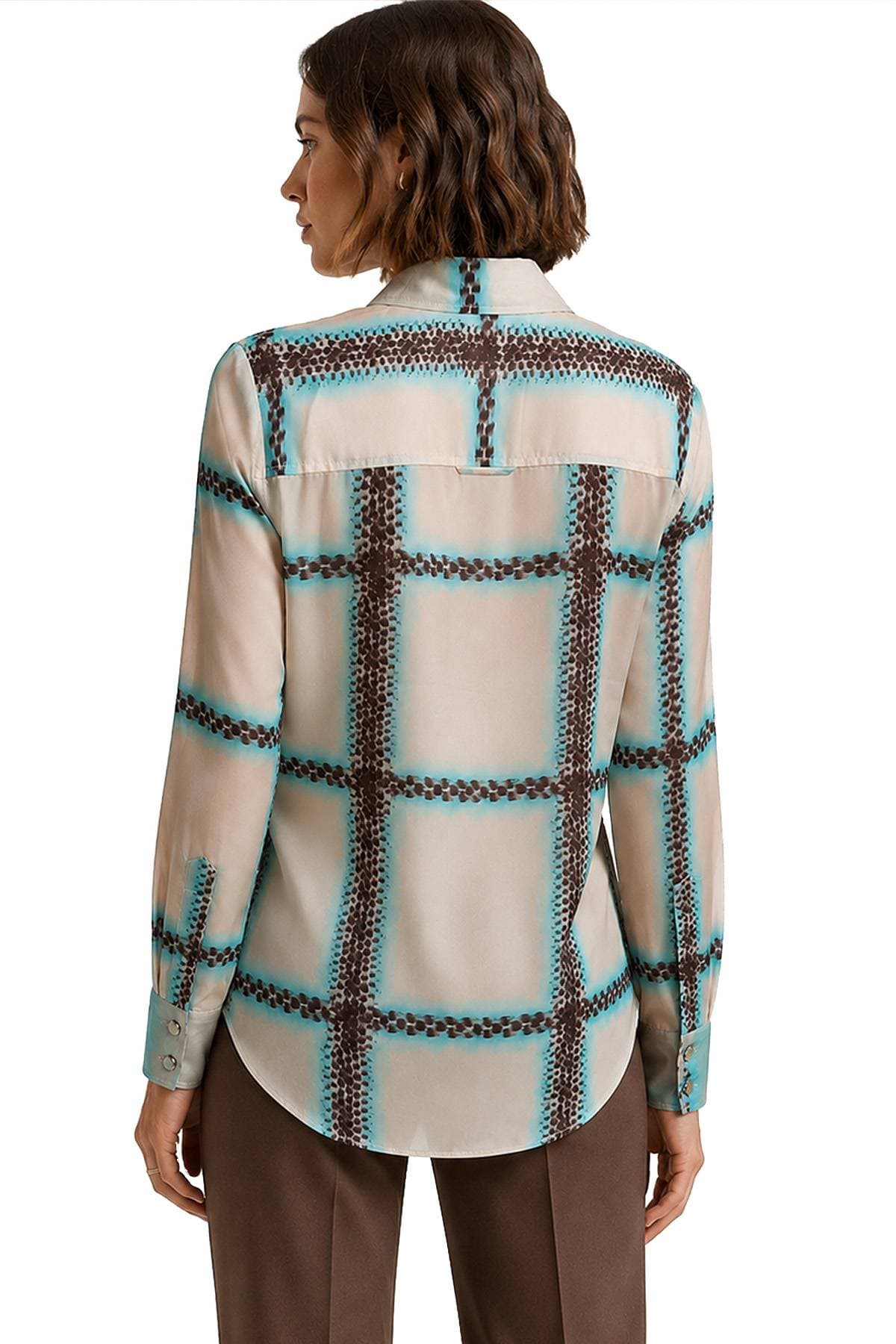A person is wearing a long-sleeved shirt with a brown and teal grid pattern.